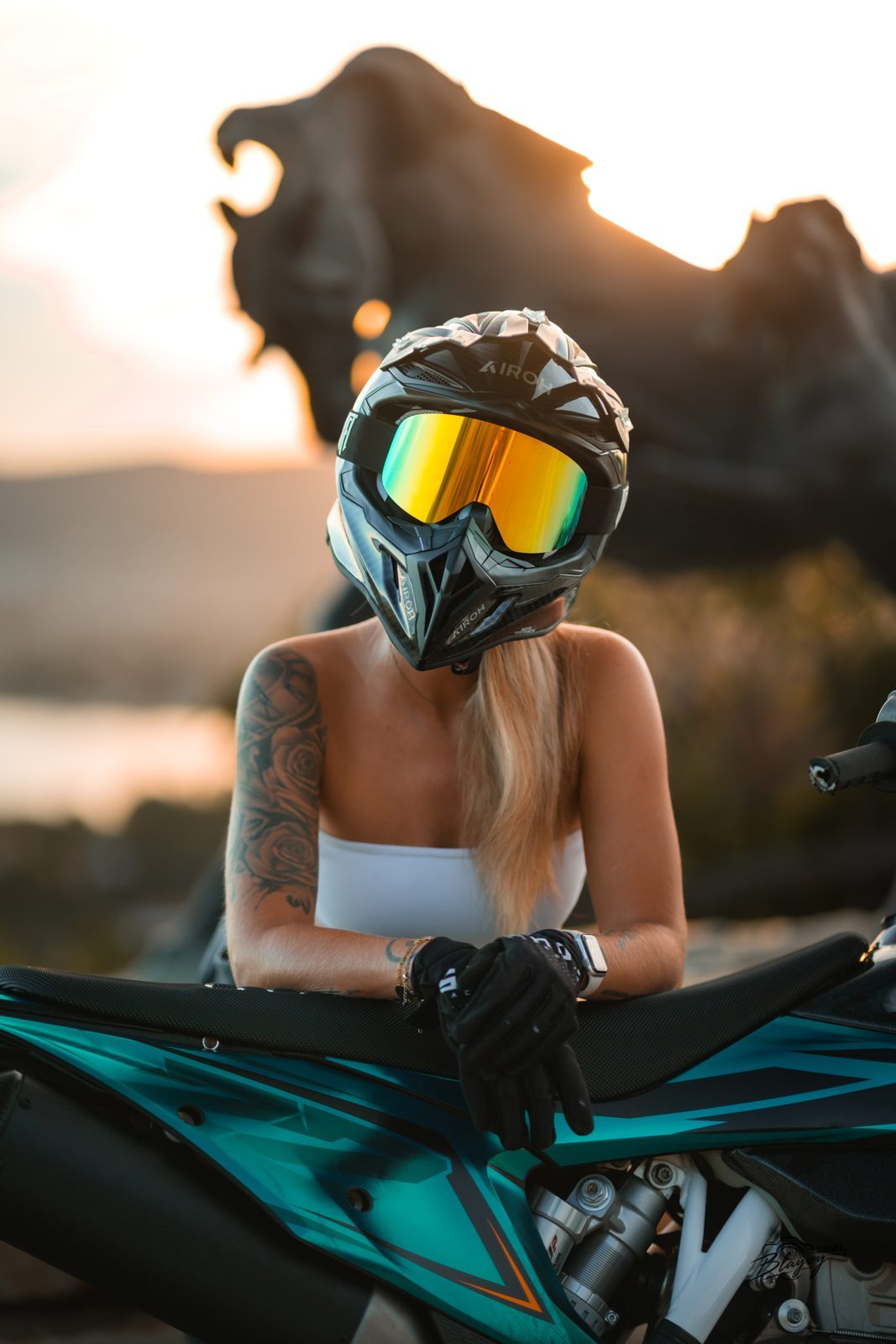 Casque et masque doré, accoudée à la moto au coucher du soleil